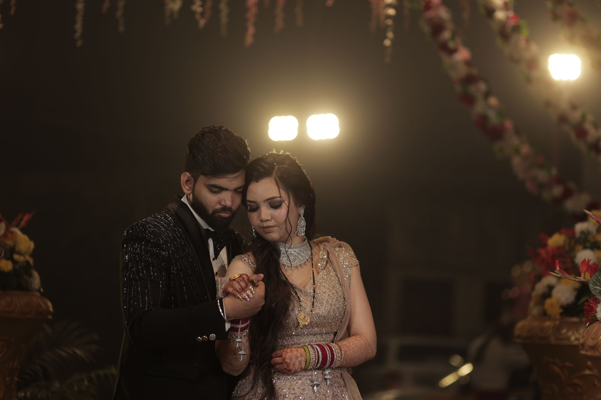 An elegantly dressed couple posing in dramatic event lighting