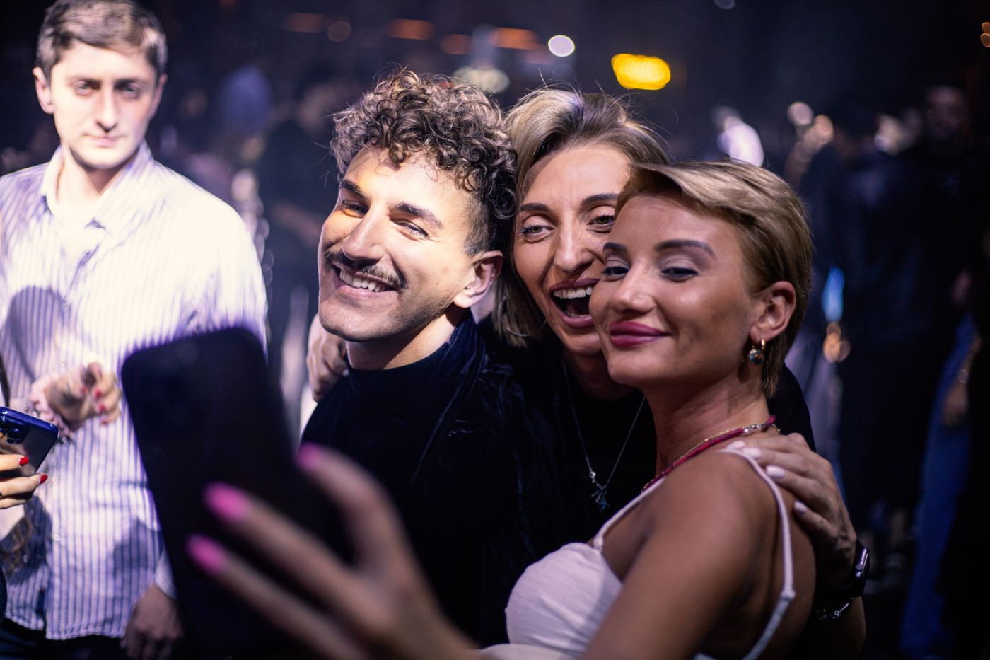 Stylish friends taking a photo at a lively event