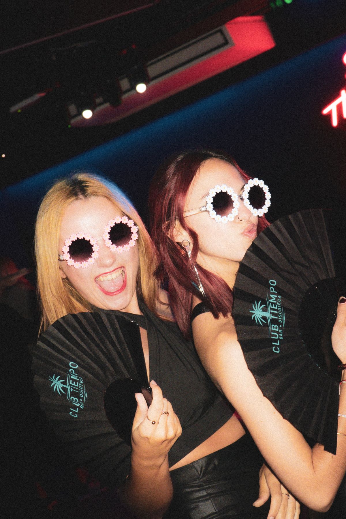 Friends posing in playful flower-shaped glasses at a nightlife event